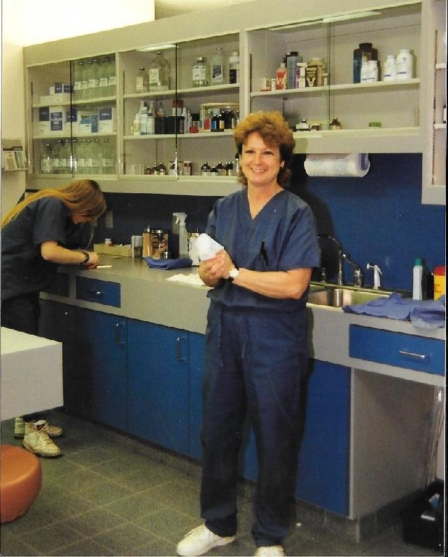 Vet staff at a sink counter in an exam room, smiling.