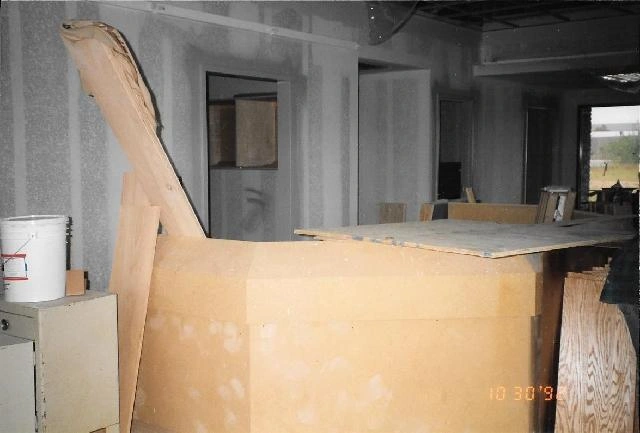 Unfinished interior with a plywood desk being built.