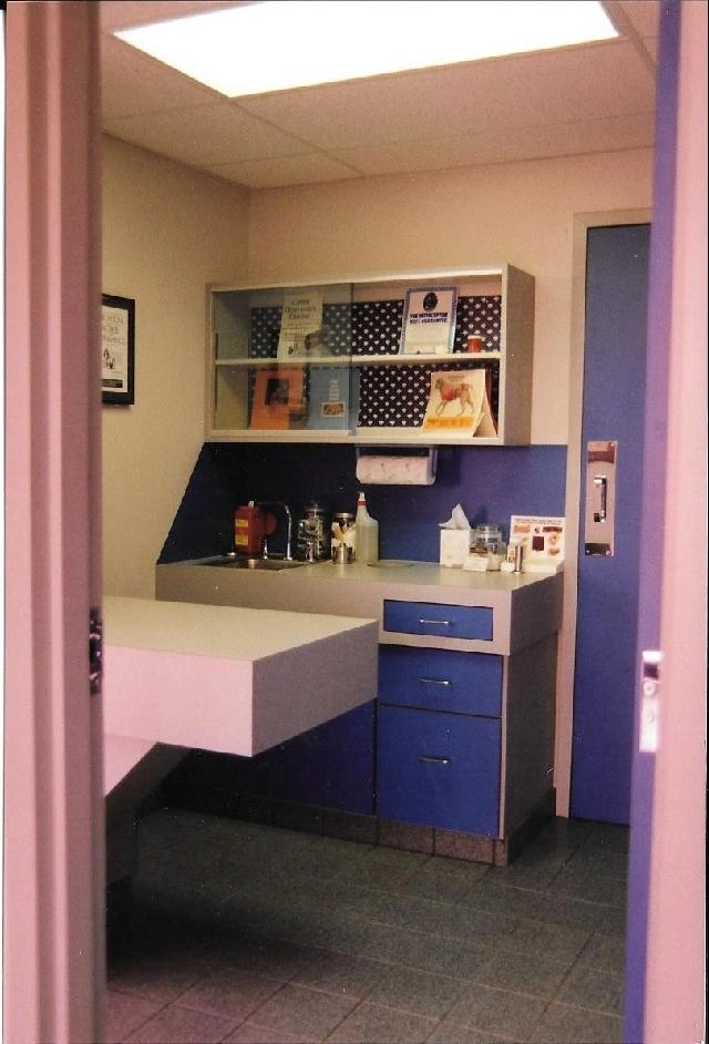 Exam room with table, cabinets, and sink.