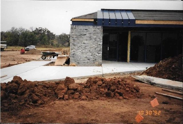 Building further along, paved lot out front.