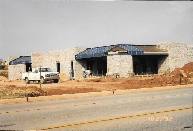 Brick building under construction, truck parked out front.